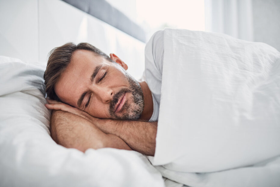 Mann schläft friedlich und glücklich im Bett