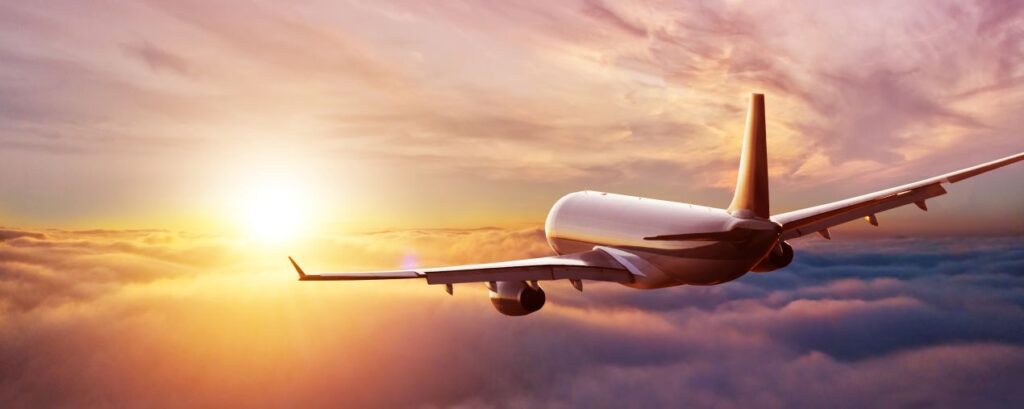 Emirates First Class Flugzeug im Sonnenuntergang über den Wolken