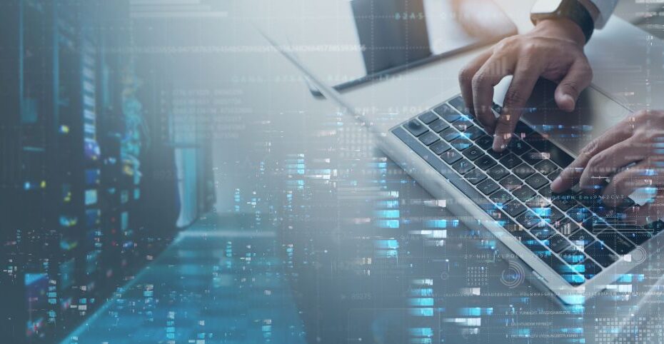 Haende tippen auf Laptop vor Serverraum – digitale Netzwerkinfrastruktur mit MPO-Verkabelung im Einsatz